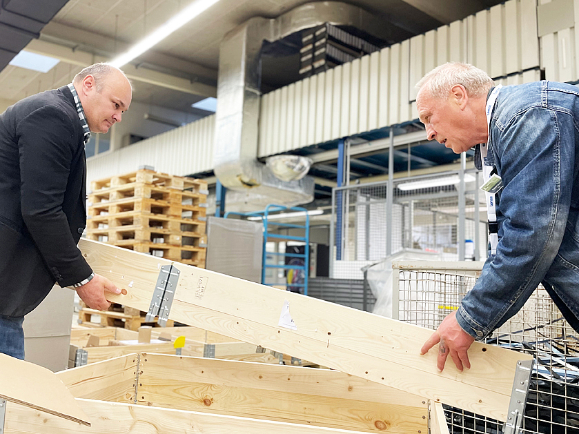 zwei Männer bauen ein Holz-Produkt zusammen
